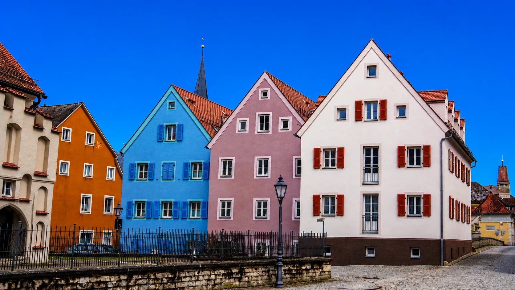 Quatre maisons colorées dans la même rue, chacune avec son verdict Pondelo